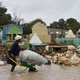 A woman pushes a wheelbarrow while walking in a partially flooded street, in the Haitian capital, Port-au-Prince, on October 4, 2016. Hurricane Matthew made landfall in southwestern Haiti early Tuesday, crashing ashore as a powerful Category Four storm, US weather forecasters said. The National Hurricane Center said Matthew made landfall as an ‘extremely dangerous’ storm near the village of Les Anglais at around 7 am (1100 GMT) with maximum sustained winds of around 145 miles (230 kilometers) per hour. (Image: Getty)